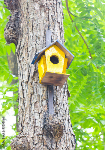 Fototapeta Naklejka Na Ścianę i Meble -  Colorful birdhouse made of wood up in a tree.