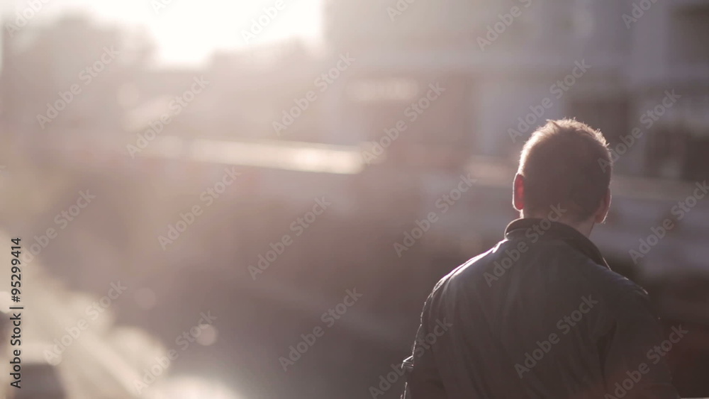 Man looks at traffic in the city in the sunset Man looks at traffic in the city in the sunset