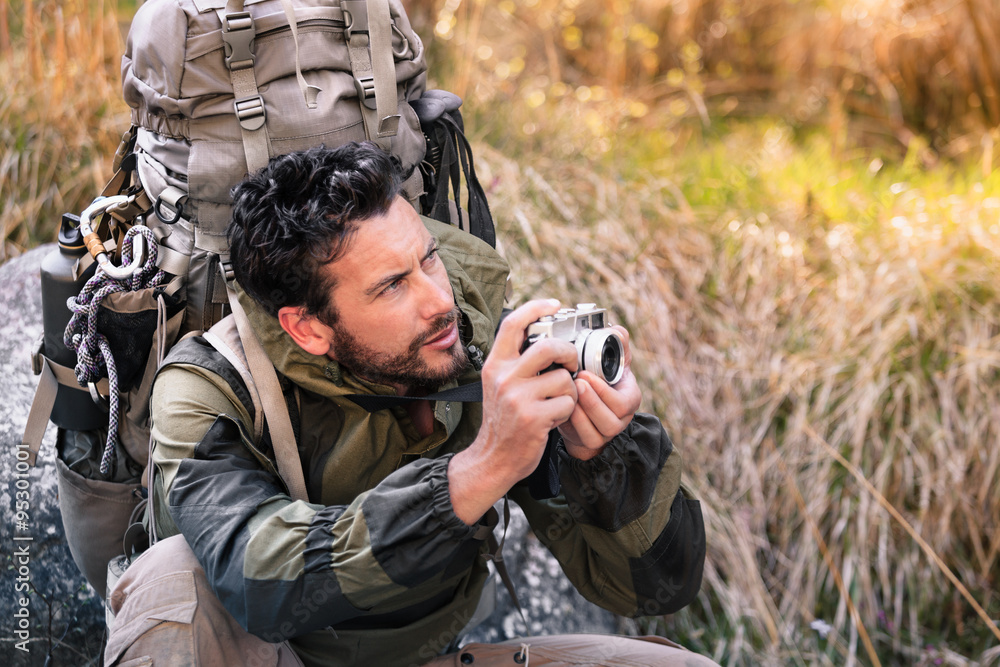 Handsome young hiker with camera