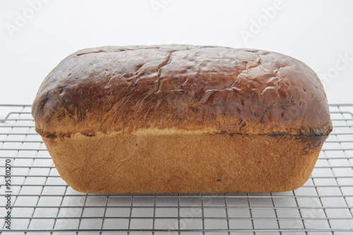 Homemade white bread on a wire cooling rack.