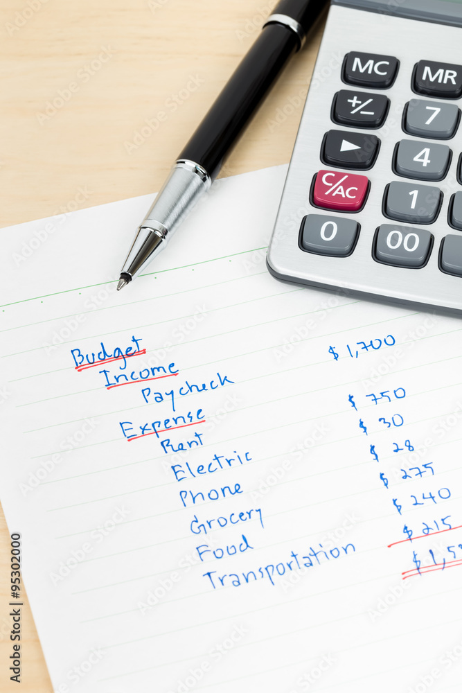 Hand writing home budget with calculator Hand writing home budget with calculator