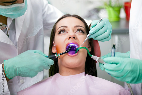 dentist is treating teeth of the female patient