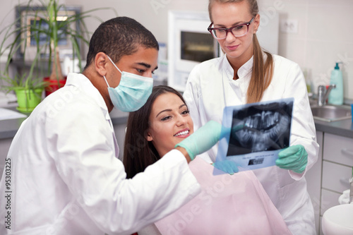 Dentist explaining the details of x-ray picture to his patient