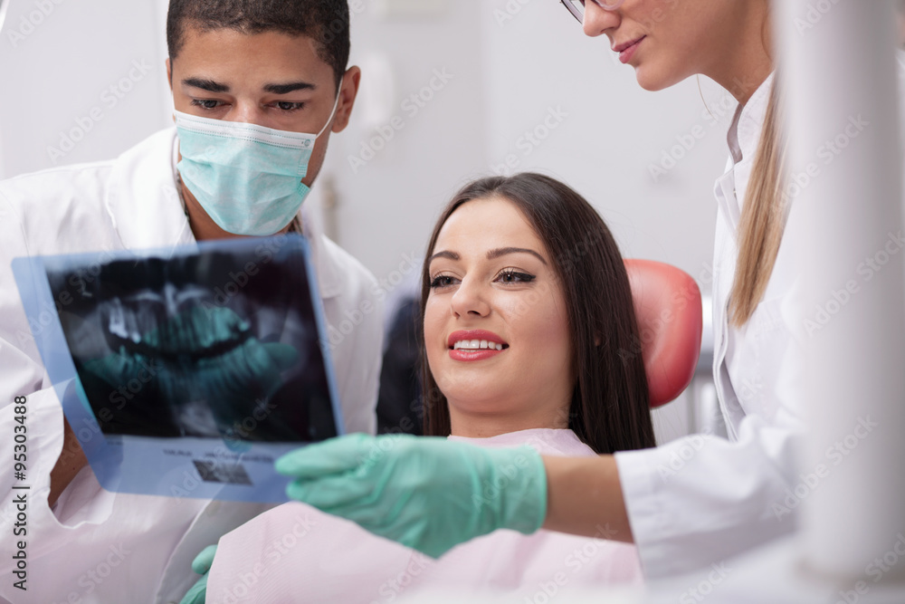 Dentist explaining the details of x-ray picture to his patient Dentist explaining the details of x-ray picture to his patient