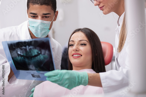 Dentist explaining the details of x-ray picture to his patient