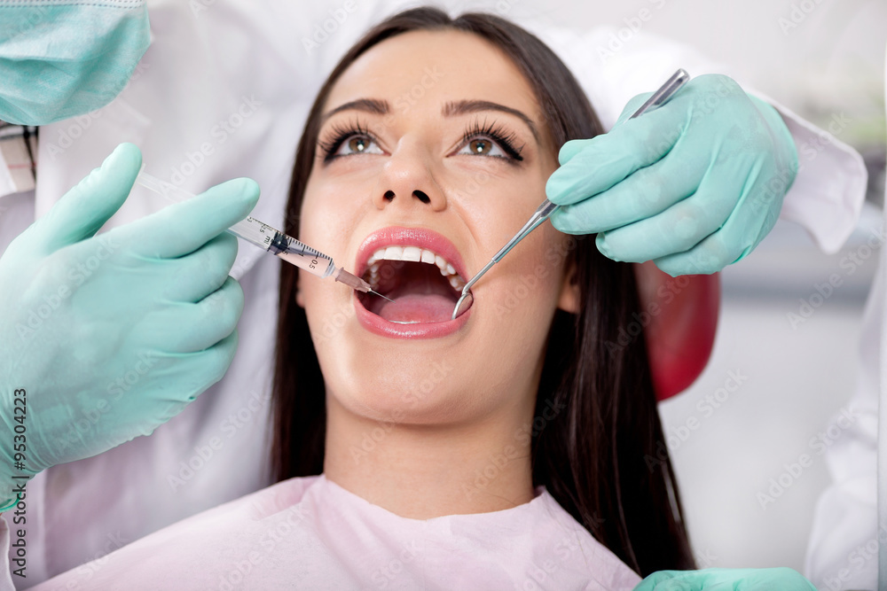 Dentist give syringe anesthetize to his patient Dentist give syringe anesthetize to his patient