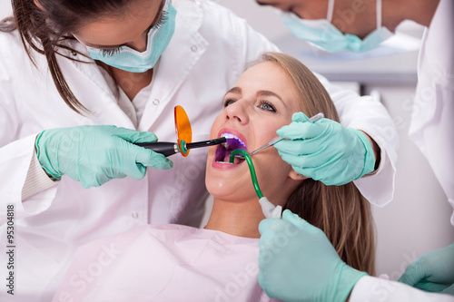 dentist is treating teeth of the female patient