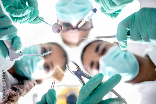 Dental team working with a patient in protective work wear