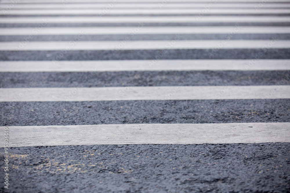 Fototapeta premium Empty urban pedestrian crosswalk in black and white across an asphalt street in downtown.