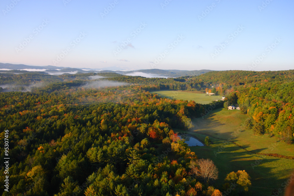 An aerial view of a hot air balloon floating over the Vermont country side ..