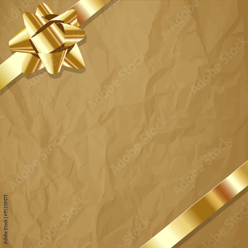 Gold ribbon on a crumpled paper brown background.
