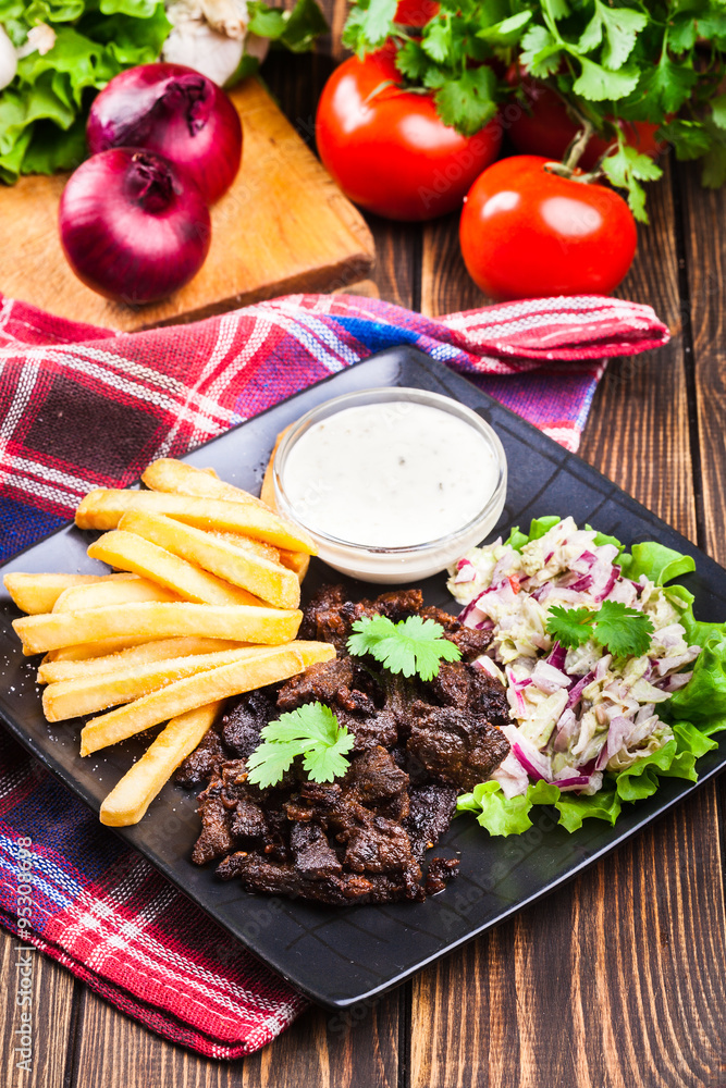 Kebab of beef with french fries and salad Kebab of beef with french fries and salad