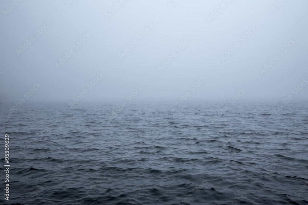 Naklejka premium Calm surface of a sea during a foggy day
