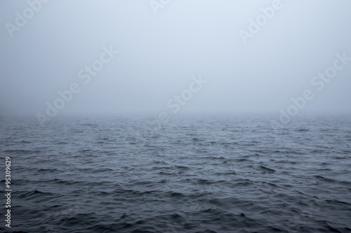 Calm surface of a sea during a foggy day photo