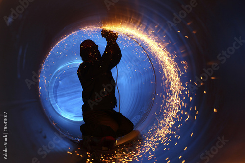 A worker works inside a pipe on a pipeline construction photo