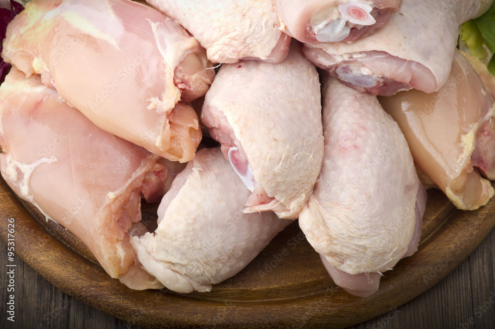 Fresh skinless chicken thighs and legs on cutting board Fresh skinless chicken thighs and legs on cutting board