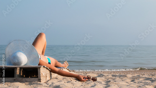 Girl with glasses sunbathes at sunset
