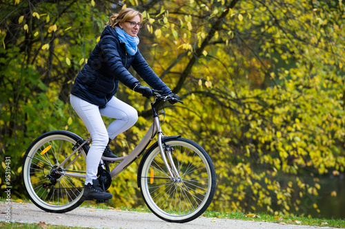 Urban biking - woman riding bike in city park 