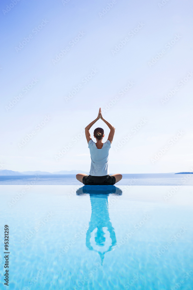 Fototapeta Young woman practicing yoga outdoors. Beautiful girl doing relaxation exercises. Harmony, balance, meditation, relaxation, healthy lifestyle, mindfulness concept
