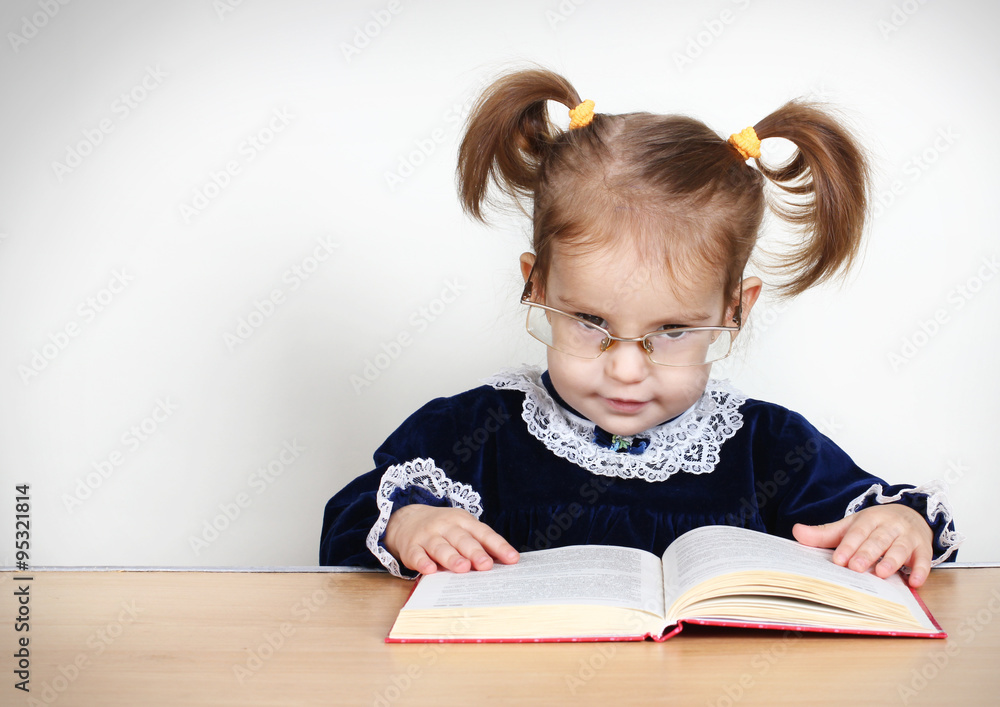 Funny little girl reading book with glasses Funny little girl reading book with glasses