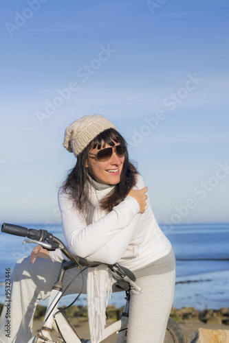 Happy woman having a break during a bike ride along the sea 