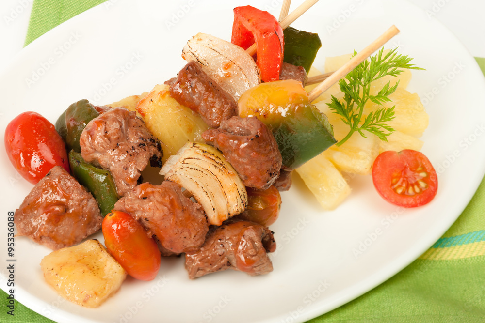 Fried barbeque meat on a bamboo sticks with vegetables