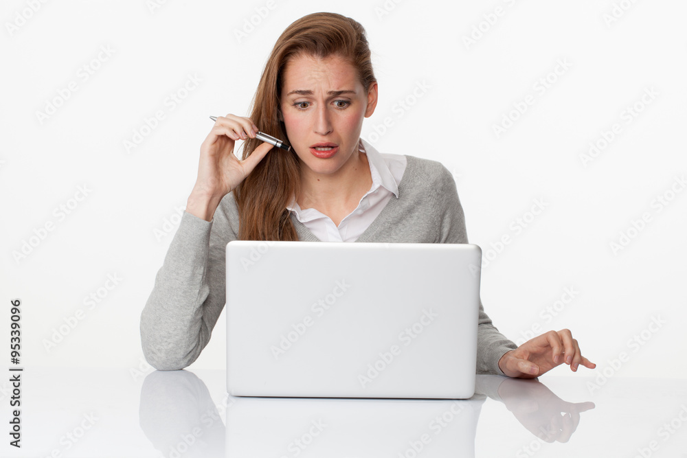 surprised 20s woman writing on pc on sparse white desk surprised 20s woman writing on pc on sparse white desk