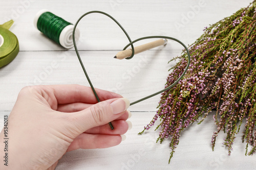 Florist at work: steps of making heather (erica) door wreath in