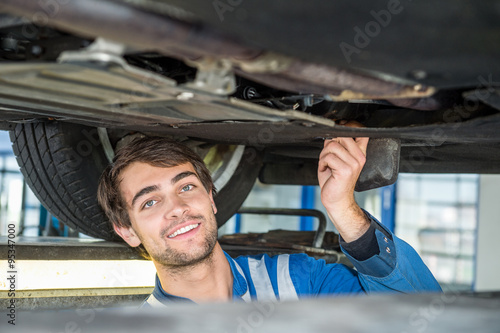 Confident Mechanic Repairing Car In Automobile Shop