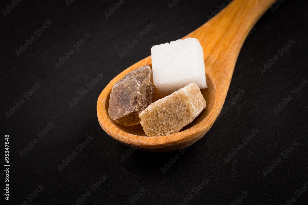 Obraz premium White refined and brown sugar in wooden spoon