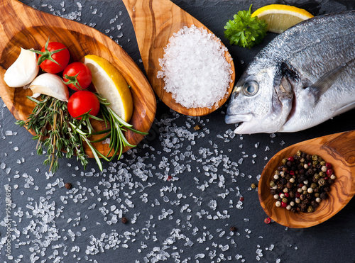 Canvas Print fresh raw dorado fish with spices and herbs on black background, top view