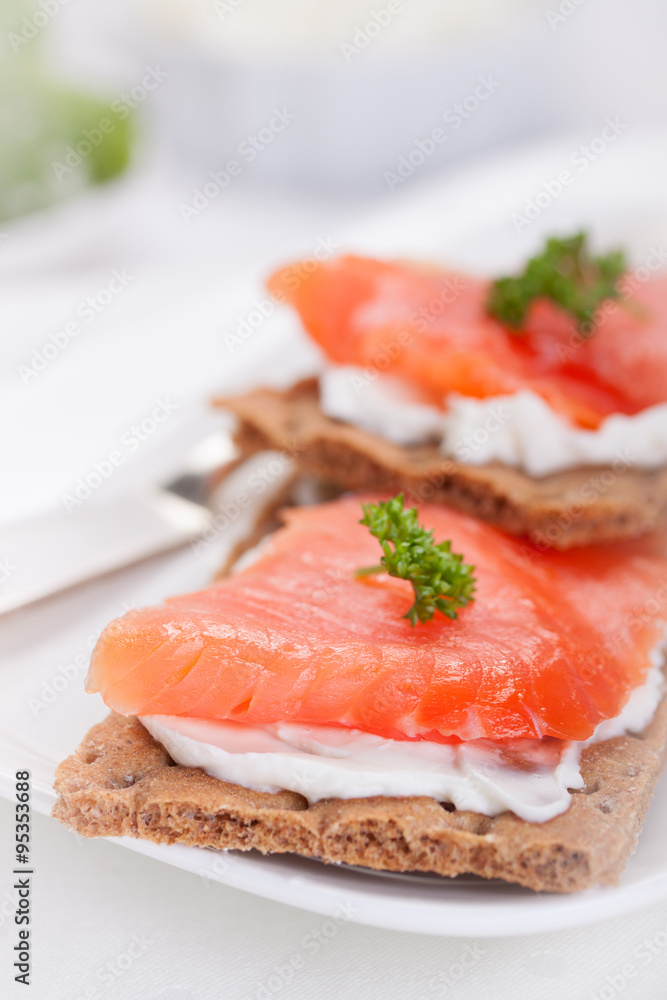 Sandwich with smoked salmon and cottage cheese on a white plate.