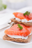 Sandwich with smoked salmon and cottage cheese on a white plate.