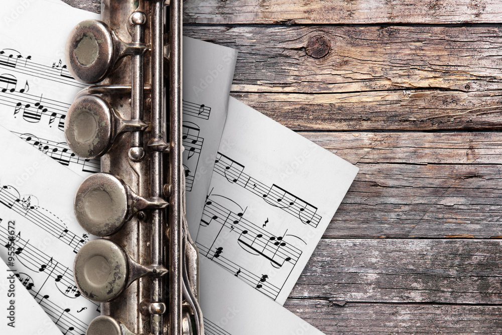 Obraz premium Old flute with sheet music on rusty wooden boards