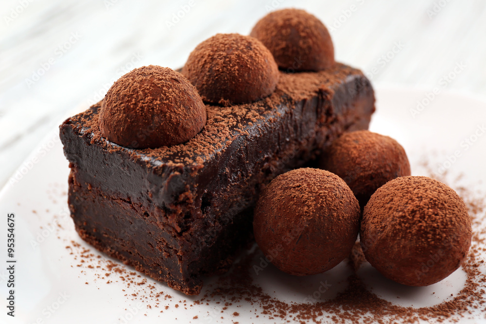 Slice of chocolate cake with a truffle on plate closeup Slice of chocolate cake with a truffle on plate closeup