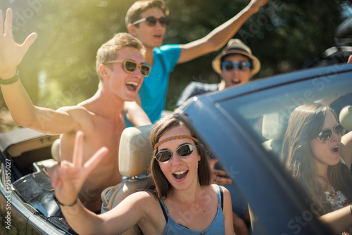Young people having fun in the summer on a black convertible.  © jackfrog