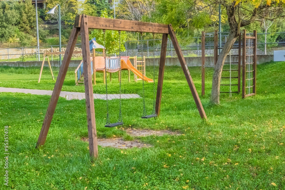 empty swings at playground for child near children stairs slides equipment