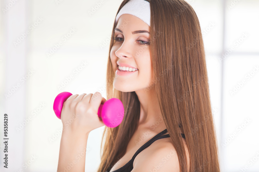 Young woman with pink dumbbells Young woman with pink dumbbells