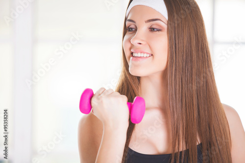 Young woman with pink dumbbells