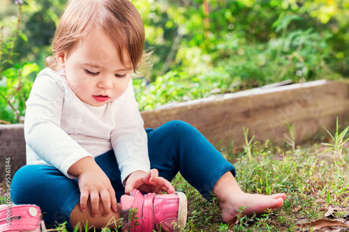 Toddler girl putting on her sneakers photo