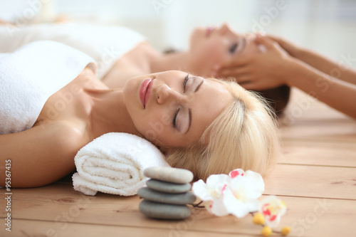 Two young beautiful women relaxing and enjoying at the spa center