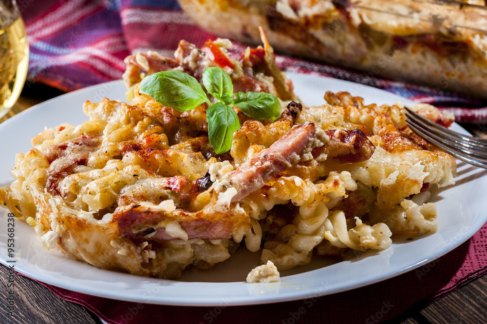 Portion of fusilli pasta casseroles, sausages and zucchini Portion of fusilli pasta casseroles, sausages and zucchini