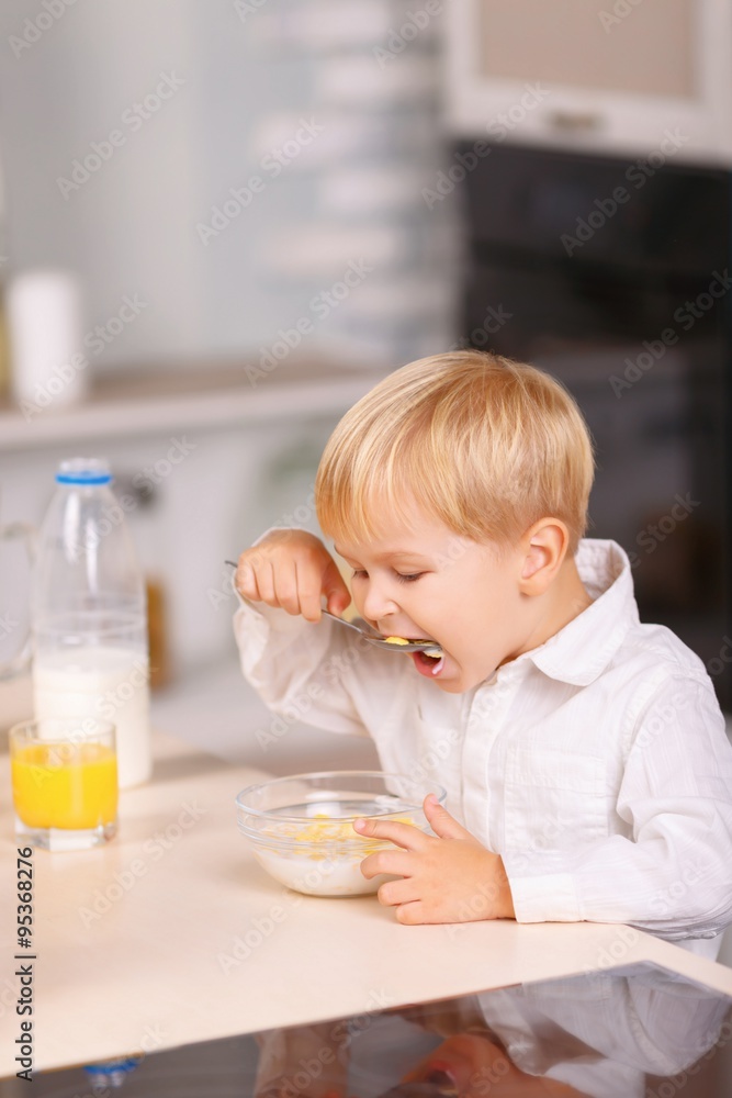 Small boy eats cornflakes with lots of appetite. Small boy eats cornflakes with lots of appetite.
