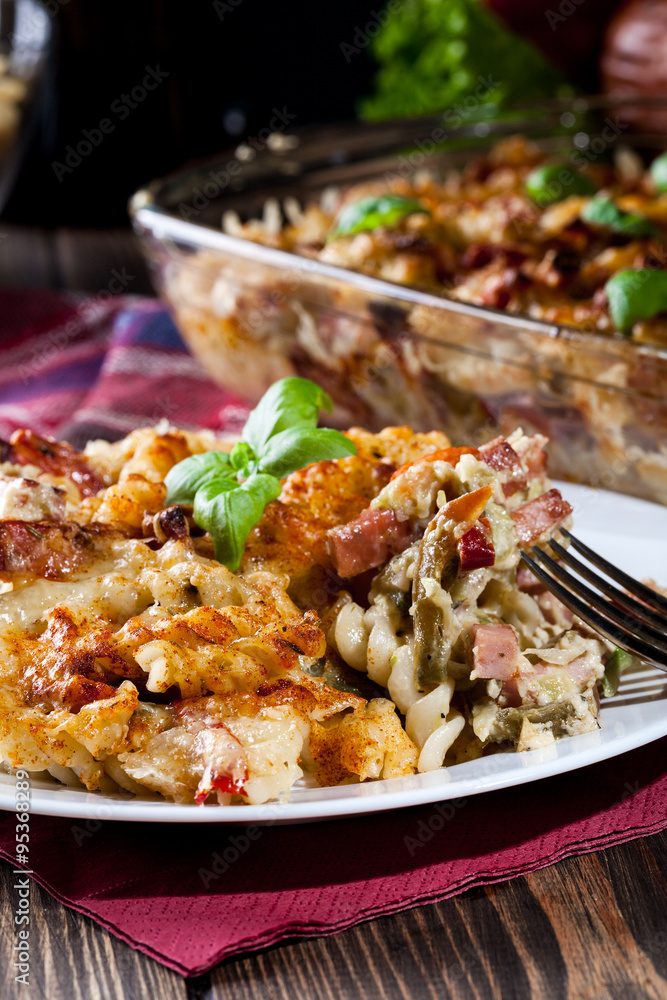 Portion of fusilli pasta casseroles, sausages and zucchini Portion of fusilli pasta casseroles, sausages and zucchini