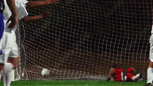 A soccer player making a penalty kick into the goal and celebrating
