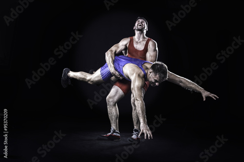 Freestyle wrestler throwing action isolated on black background