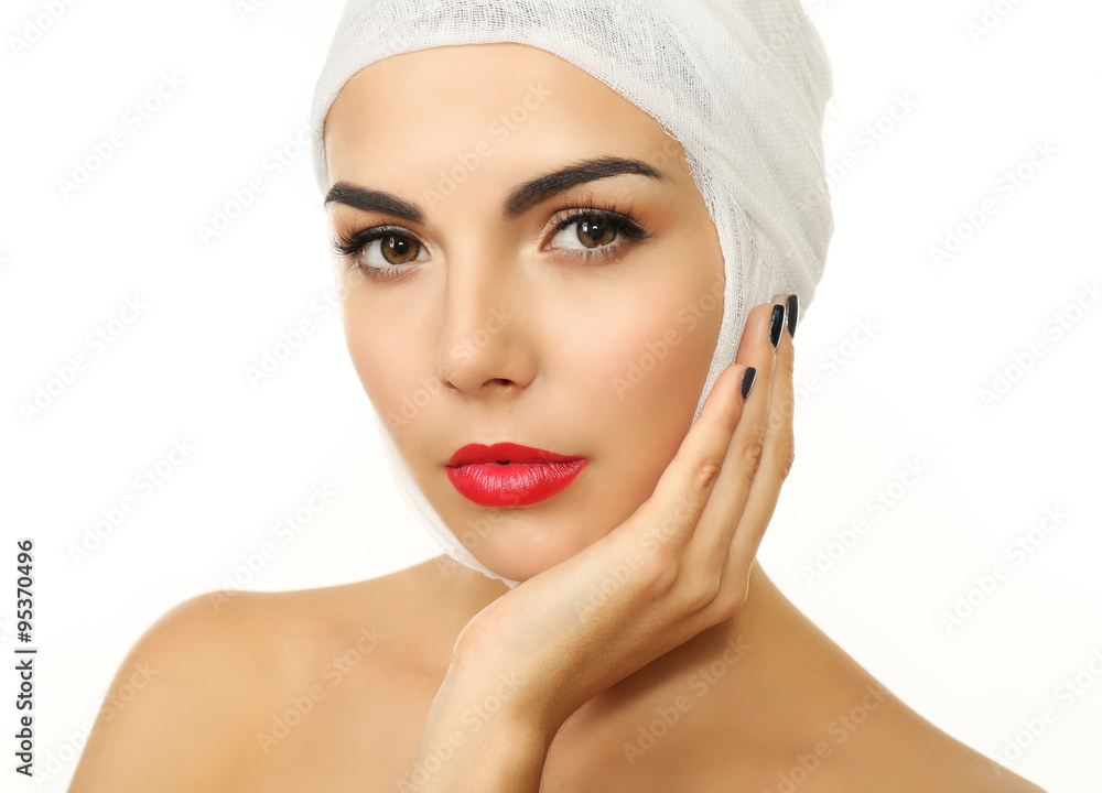 Young beautiful woman with a gauze bandage on her head, isolated on white, close-up Young beautiful woman with a gauze bandage on her head, isolated on white, close-up