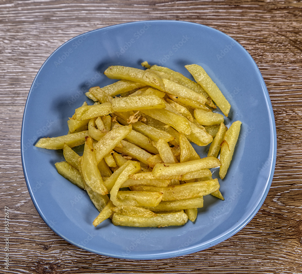 French fries on the plate on wooden background French fries on the plate on wooden background