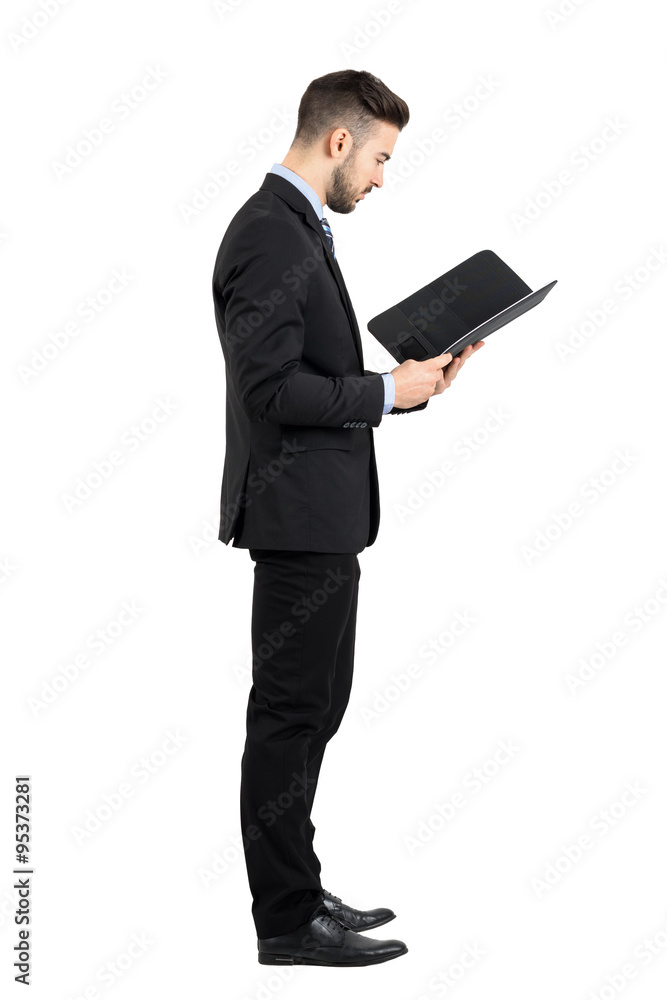 Businessman in suit reading document or contract side view. Full body length portrait isolated over white studio background. Businessman in suit reading document or contract side view. Full body length portrait isolated over white studio background.