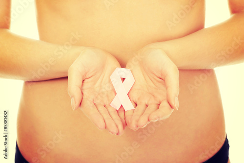 Female hands holding pink ribbon.